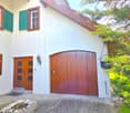 white house, wooden garage, wooden door, green shutters, lamp