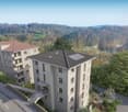A modern apartment building with multiple floors, large windows, a small garden, solar panels on the roof, and a scenic view of the hills.