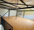 open floor with wooden planks, black railings, metal framework