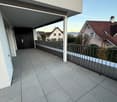 large empty balcony with tile flooring and metal railings, entrance door on left