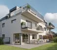Modern 3-story house, white exterior, multiple balconies, large windows, outdoor dining area, garden