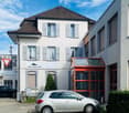 2 story house, brown roof, white walls, grey shutters, windows, car parked in front, red entrance glass