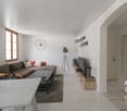 white walls, couch, coffee table, tv, rug, windows