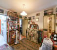 Entrance hall with wooden shelves, framed pictures on the wall, carpet, and a table with umbrellas