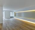 empty room, wooden floor, white walls, yellow lighting on wall, windows