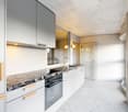 modern kitchen, white cabinets, granite countertop, stainless steel appliances, white tiled floor