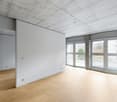 empty room with wooden floors, large windows, balcony