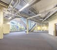Large open area, wide stairwell, no furnishings or decor, high ceiling, industrial aesthetic
