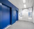 elevator, blue walls, white ceiling, white doors, glass doors, gray carpet