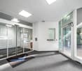 Empty room with glass walls, automatic sliding doors, carpet, fire extinguisher, and a sign that reads 'TestingTime'.