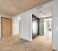 Empty room with wooden floor, white walls, wooden door, built-in wardrobe, and ceiling lights