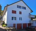 3 story house, white exterior, 3 garages, balcony, car parked in front