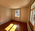 empty room, wooden floor, white walls, large windows, sliding door, radiator