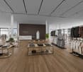 Spacious interior with wooden floor, large windows, central pillar, clothing racks, tables, plants, and shoes on display.