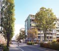 A modern apartment building with multiple balconies, surrounded by trees and greenery.