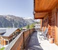 balcony with chairs, wooden railing, wooden house, mountain view