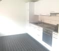 modern kitchen, tiled floor, white cabinetry, granite countertop, integrated dishwasher, washing machine, stainless steel stove, and a sink with faucet
