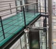 glass-paneled balcony, open glass-paneled railing, staircases on two sides