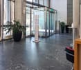large lobby, marble flooring, large windows, plants, round table, lamp