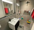 Bathroom with white sink, mirror, shower, and tiled floor