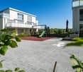white multi-story apartment building, balcony, play ground, slide, swing