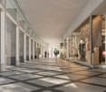 Modern retail arcade, glass columns, tiled floor, several shops, people walking.