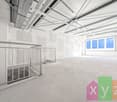 Large open space with high ceilings, exposed beams, and windows. The space appears to be a commercial or industrial building, with a balcony or terrace visible.