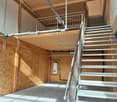 wooden walls, steel stairs, metal handrail, wooden mezzanine with metal railings