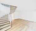 modern staircase with concrete steps, white handrail, beige floor