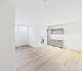 empty room, modern design, wooden flooring, white walls, white ceiling, kitchen area with sink and cabinets