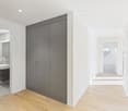 Bathroom with wooden floor, white walls, sink, large gray built-in closet, adjacent shower room