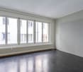 empty room, large windows, white walls, radiator, gray floor