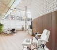 Minimalistic interior with wooden flooring, white walls, two chairs, desk, and a large glass window.