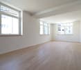 empty room, wooden floor, white walls, three windows, power outlets
