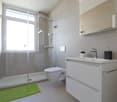 modern bathroom with shower, toilet, sink, and mirror
