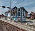 Train station with a small building, benches, and a platform