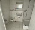 white tiled bathroom, sink, shower, toilet, mirror, bathtub
