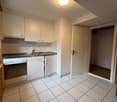 modern kitchen with white cabinets, tiled floor, sink, oven, and a door leading to a closet