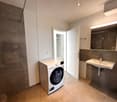 small bathroom with washing machine, sink, mirror, and small closet
