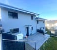 House with two floors, paved front yard, white doors, glass windows, staircase, metal railing, lawn