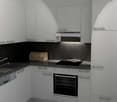 modern kitchen with white cabinets, black countertops, integrated dishwasher, oven, and sink with faucet