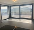 Empty room with large windows, tiled floor, modern design, balcony view