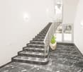 A modern interior with a black marble staircase and a silver handrail. The walls are white, and there is a large potted plant by the staircase.