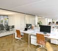 modern office, white desks, leather chairs, wooden floors, glass walls, computer monitors, lamps, shelves with books, conference table, glass doors