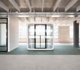 Modern interior with green flooring, white glass door, industrial style ceiling, large window with view