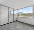 empty room, large windows, city view, mountains in the distance