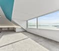empty room, large windows, concrete floor, white walls, blue accent wall, view of water and mountains