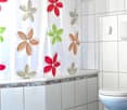 modern bathroom with white tiles, a white shower curtain, a toilet, a countertop, and a switch for lighting