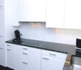 fully equipped kitchen, white cabinets, black countertops, dishwasher, stove, oven, microwave, sink, faucet