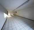 white tiled floor, white walls, ceiling with lights